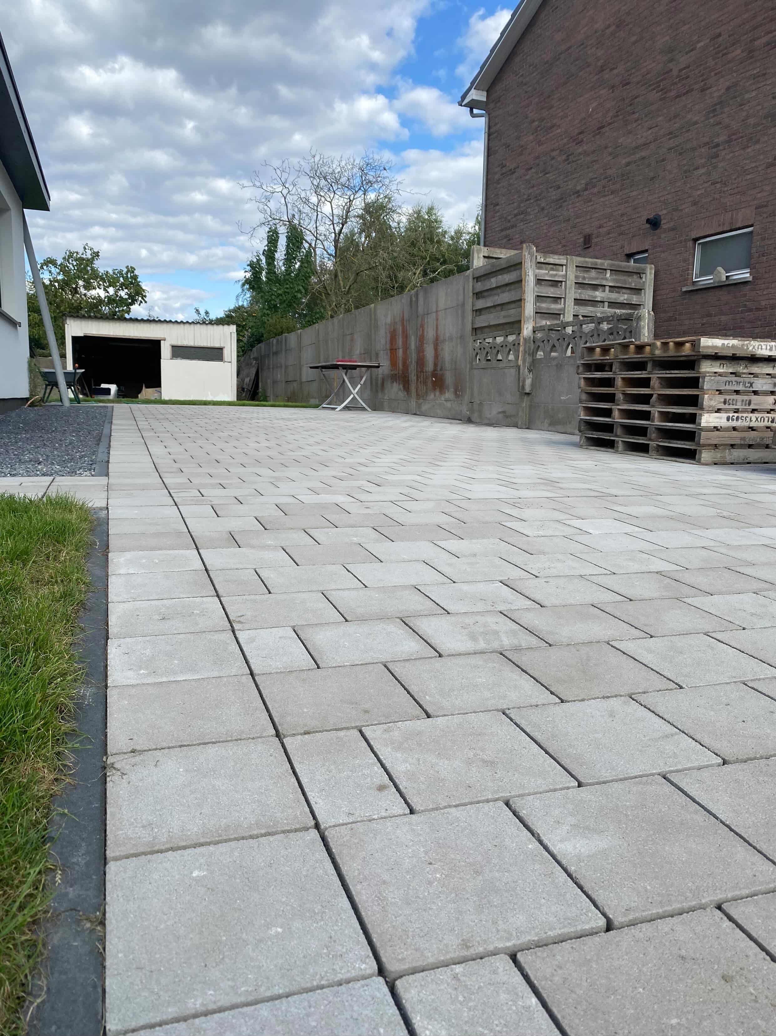 Oprit en kiezelaanleg door TuinXpert — betonnen pad en kiezelstroken