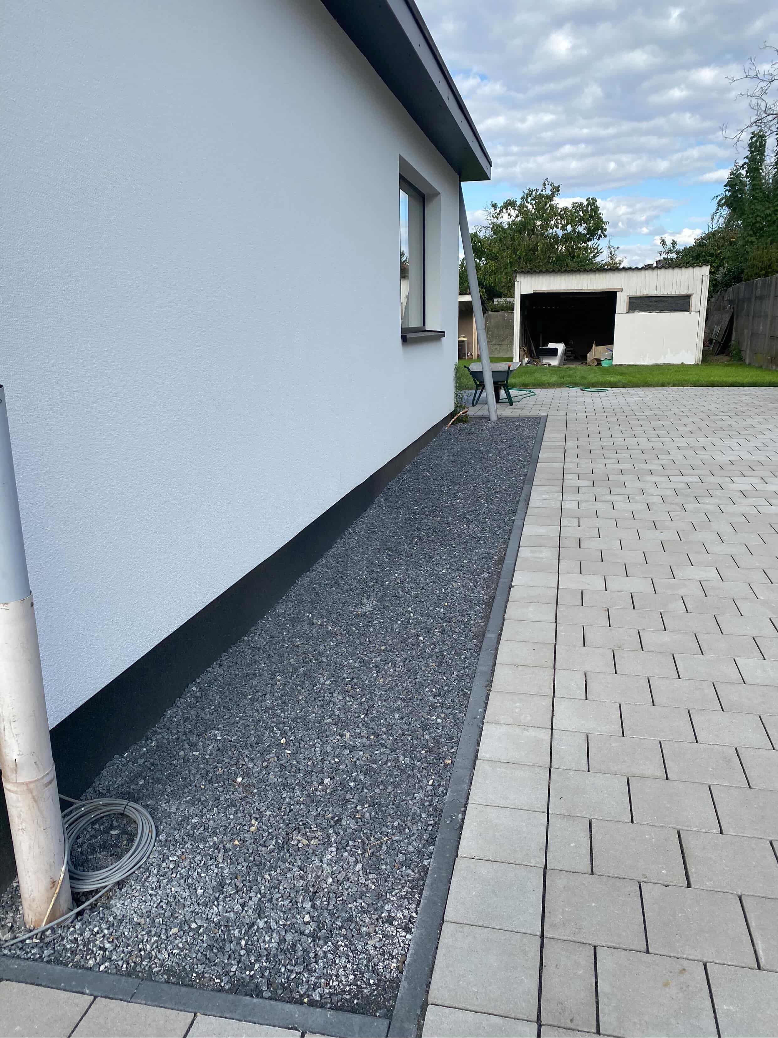 Oprit en kiezelaanleg door TuinXpert — betonnen pad en kiezelstroken